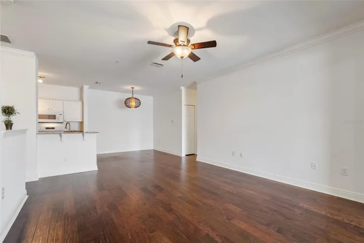 From the alcove the view of dining area and kitchen breakfast bar. Newer lighting and ceiling fans.