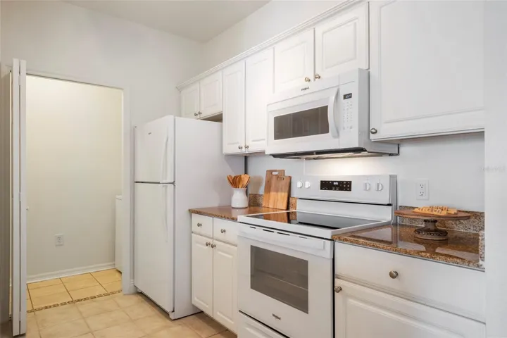Brand new refrigerator, granite countertops and microwave equipped with lighting for stove top.