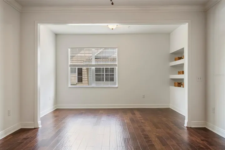 Living area can accommodate a sectional sofa, has a large wall for TV and double windows for natural lighting.