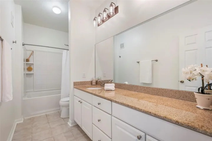 2nd Bathroom in hallway adjacent to bedrooms 2 and 3. Oversized vanity with drawer stack and two sets of cabinets for plenty of storage. New lighting, freshly painted and flexible tub/shower combination.