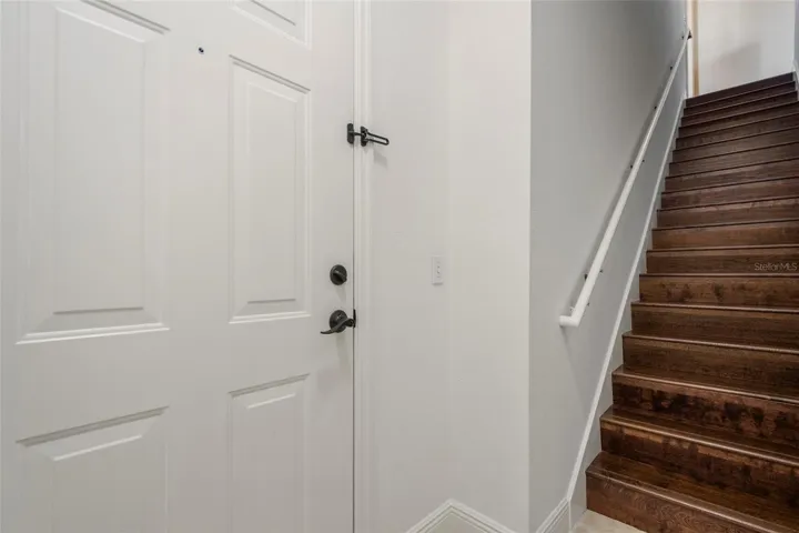 Secure entry door with dead bolt function, railing on staircase and engineered wood on staircase.