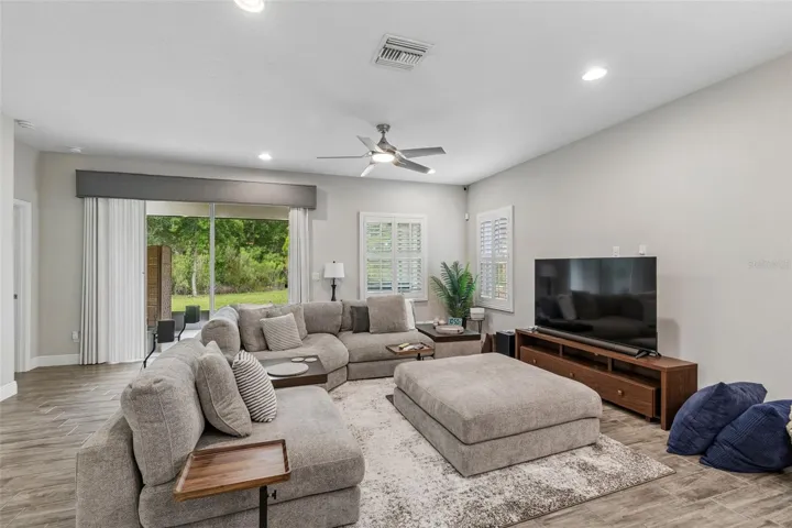 Light and bright family room with custom blinds on sliders and plantation shutters