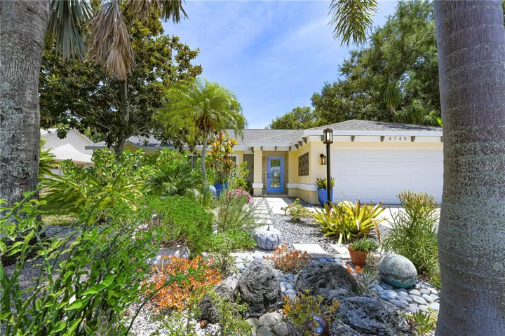 Front yard of the home with beautiful landscaping and mature trees