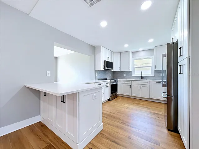 Large Kitchen with new appliances, breakfast bar, and pass through window