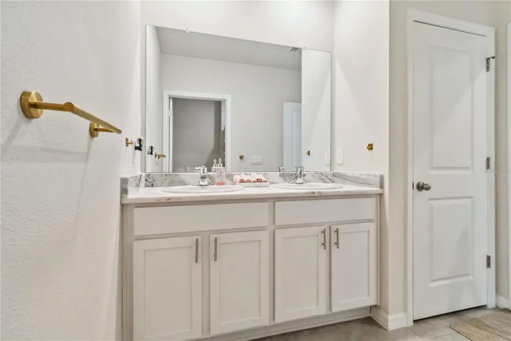 Bathroom #3 with dual sinks and a private shower/tub and water closet area