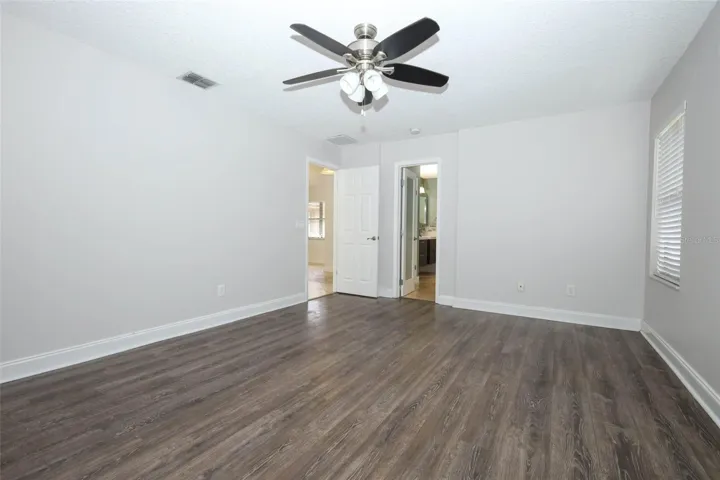 Primary bedroom with engineered hardwood flooring.