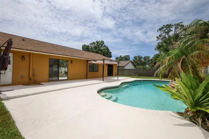 Rear yard with an open-air sparkling pool with space for the kids and pets to play.