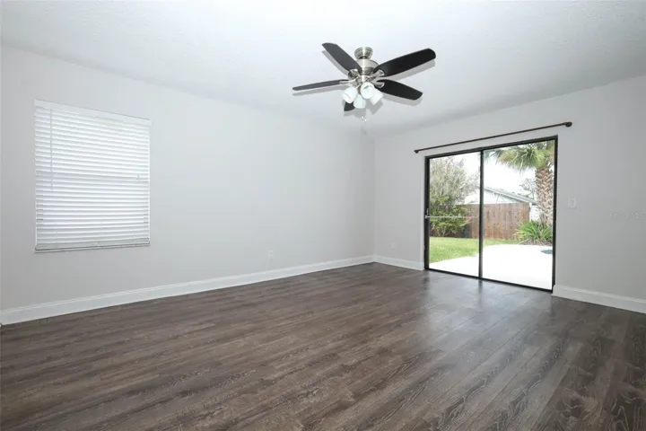 Primary bedroom with engineered hardwood flooring.