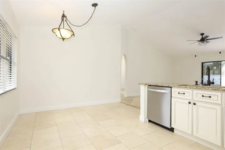 Eat-in space in kitchen with travertine tile flooring, granite countertops and stainless steel appliances.