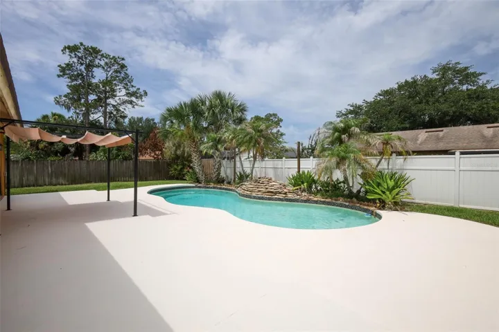 Rear yard with an open-air sparkling pool with space for the kids and pets to play.