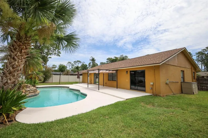 Rear yard with an open-air sparkling pool with space for the kids and pets to play.