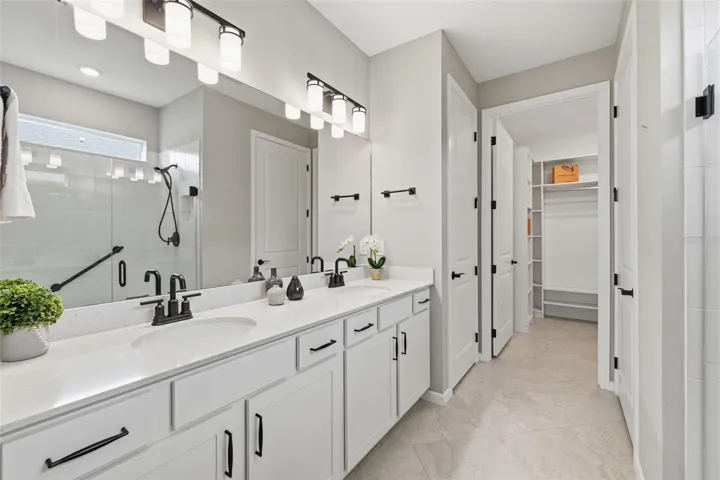Primary en suite with double sink Quartz vanity, water closet, seamless glass shower, walk in closet