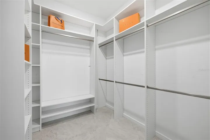 Primary walk-in closet with custom built-in shelving
