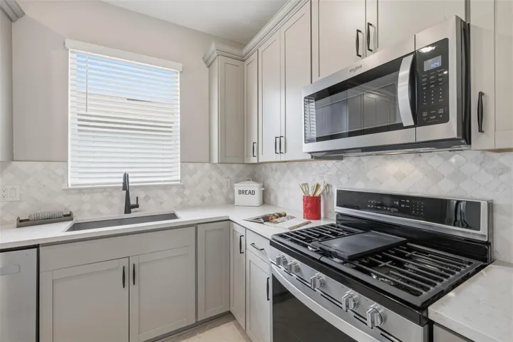 Gas range with flat top cooktop, Marble blacksplash, Quartz countertops