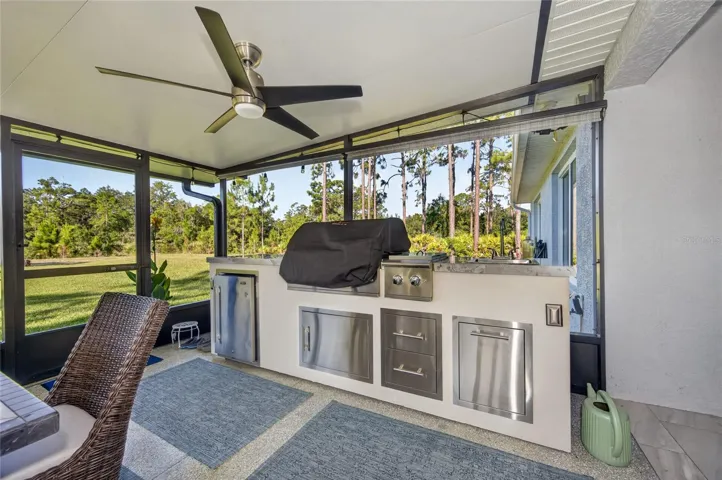 Outdoor kitchen has grill, refrig, cold water sink, warming units and covered trash