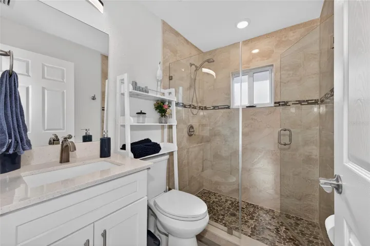 Hall bathroom with shower and glass shower door and wall