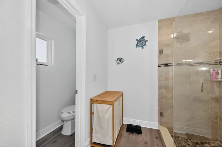 Shower with glass door and wall, plus separate toilet space