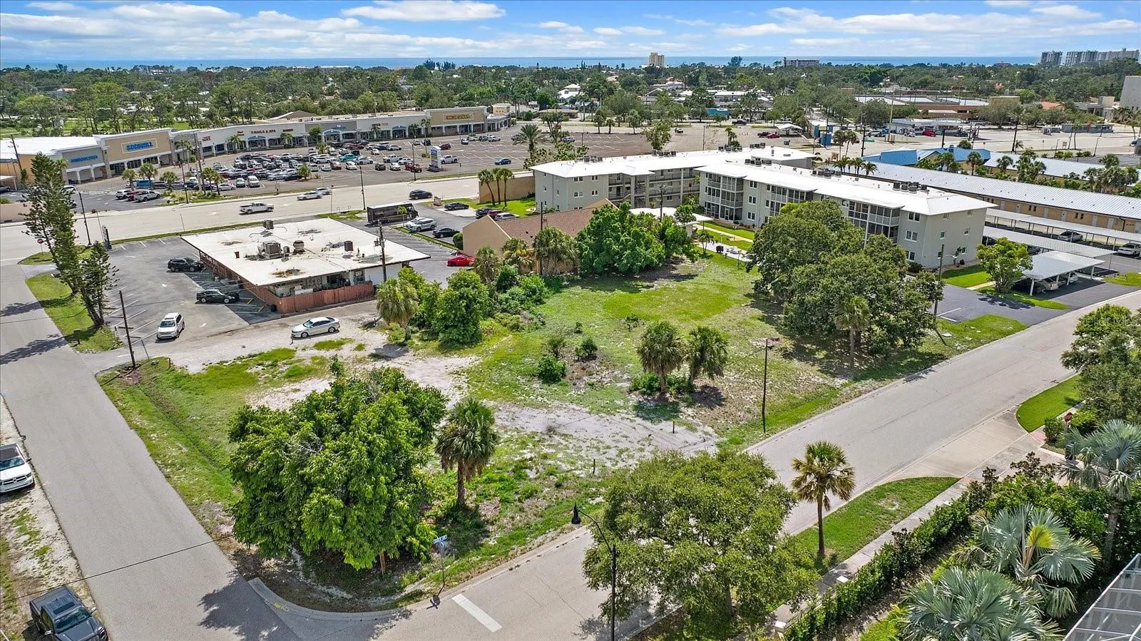 Aerial view of the lot facing the shopping plaza and nearby condominiums