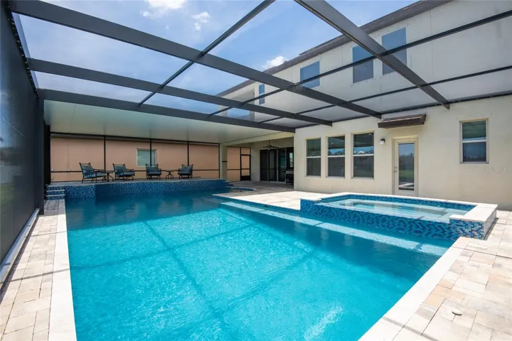 Electric heated saltwater pool with a spa, waterfall, shelf all overlooking the pond.