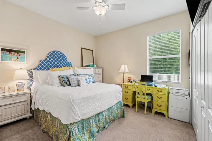 Bedroom four with ceiling fan, large built in closet, and green tree view from window in Tampa FL 33647