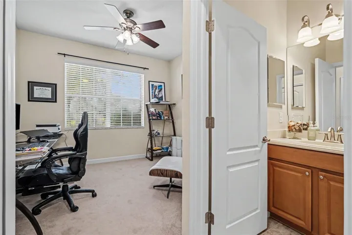 Bedroom two (junior suite via pocket door access) and adjacent full bathroom doorway showing split bedroom layout in Tampa FL 33647