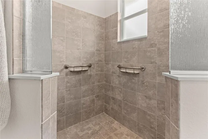 Oversized shower with custom grab bars and seat...