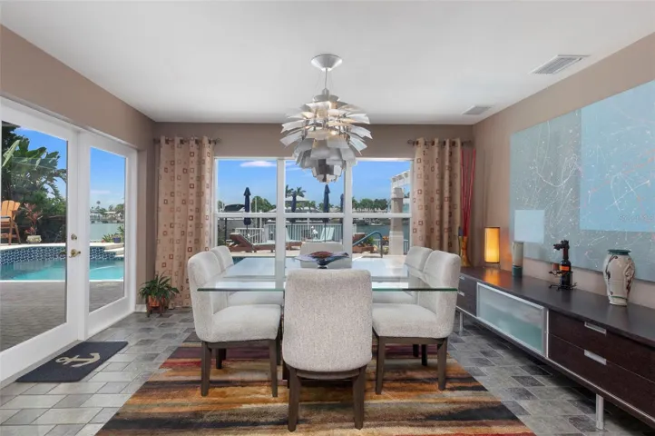 Dining area overlooks the backyard oasis with French doors leading to the pool area