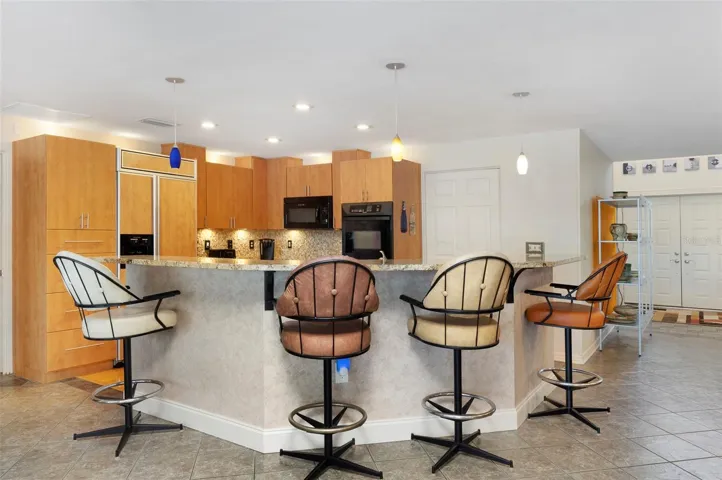 Large island with granite countertop is heart of home and is perfect place to gather with friends and family