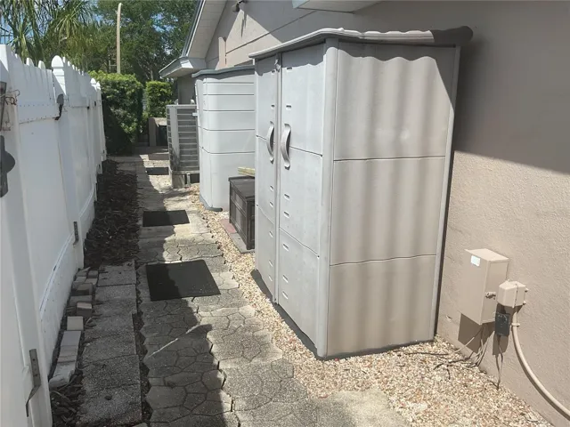 Fenced side of house with 2 storage sheds