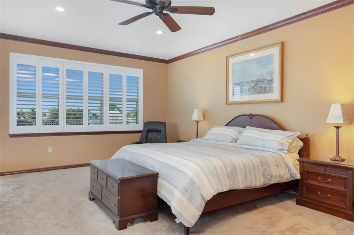 Master bedroom has plantation shutters on windows that look out over the Bay