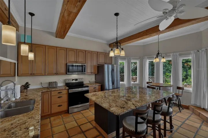 Kitchen with Granite, ss appliances, large center island and wood beam ceiling