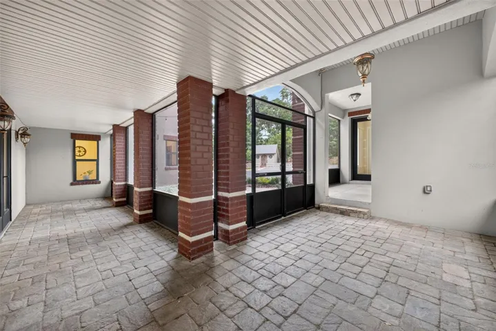 First level screened patio; doorway to the right leads to the apartment and 3-car garage. Exercise room also located here.