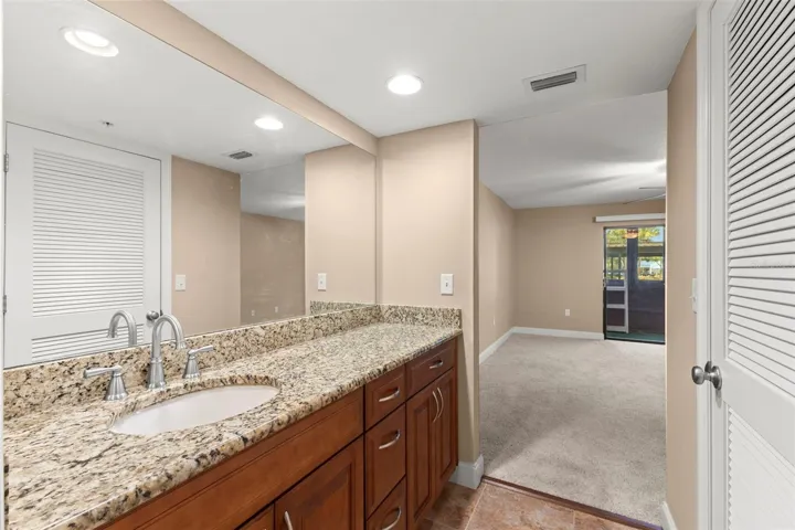 The ensuite bath offers a granite-topped vanity, ample storage, and convenient access from the primary bedroom.