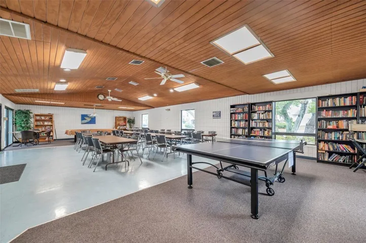 Clubhouse recreation area featuring table tennis, a resident library, and multiple seating areas for games and socializing.