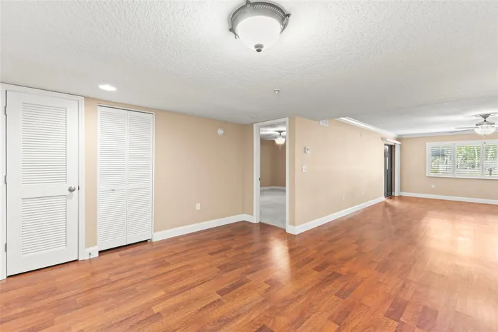 The spacious open living and dining areas have been thoughtfully updated with wood-look flooring, crown molding, wide baseboards, and a seamless connection to the kitchen and enclosed porch.
