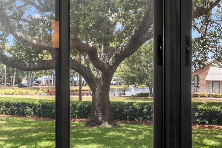 Scenic views of mature oak trees, manicured grounds, and a tranquil pond with fountain.