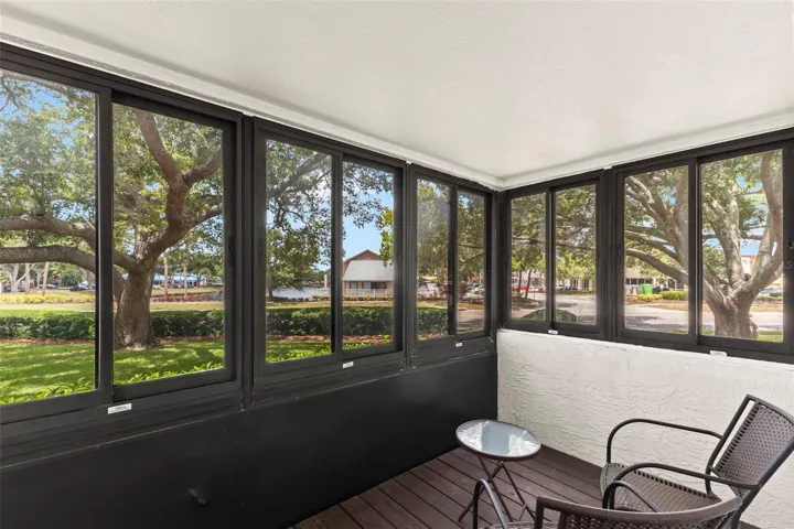 Wall-to-wall windows frame peaceful views of mature oak trees, manicured grounds, and the community pond.