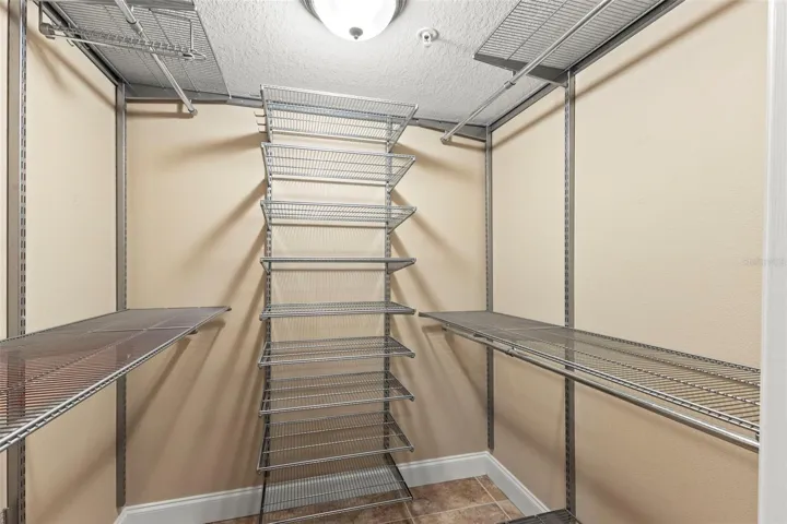 The walk-in closet features an organized shelving system with ample space for clothing, shoes, and accessories.