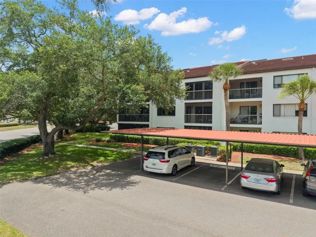 Ground-floor corner residence set within a beautifully maintained community featuring mature landscaping, expansive green space, and covered parking.