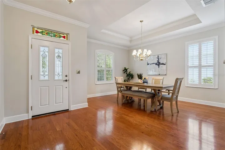 Foyer entryway & a 12' x 15' Dining Room w/ a tray ceiling, crown molding & Plantation style shutters