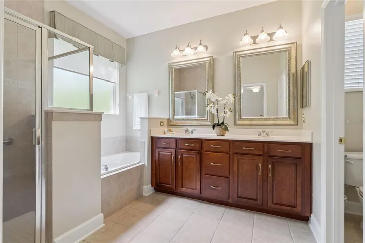 Primary Bathroom w/ raised height vanity, dual sinks & decorative picture mirrors