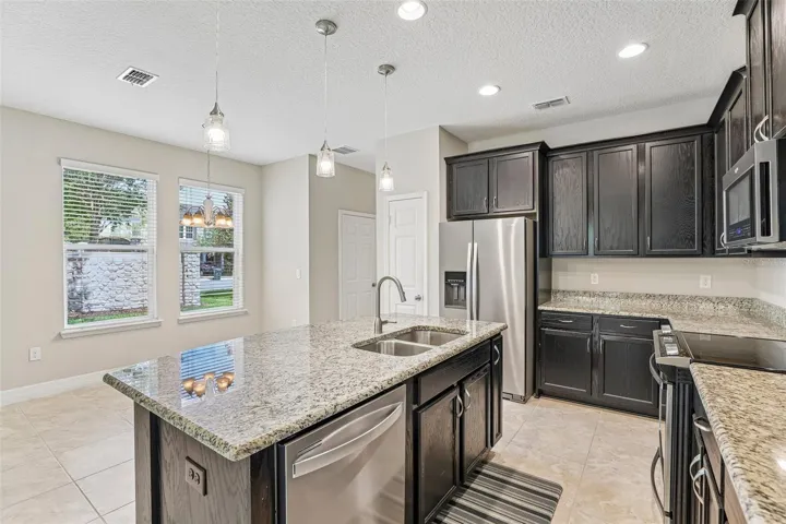 Kitchen features stainless steel appliances, ample storage and a large island with bar seating.