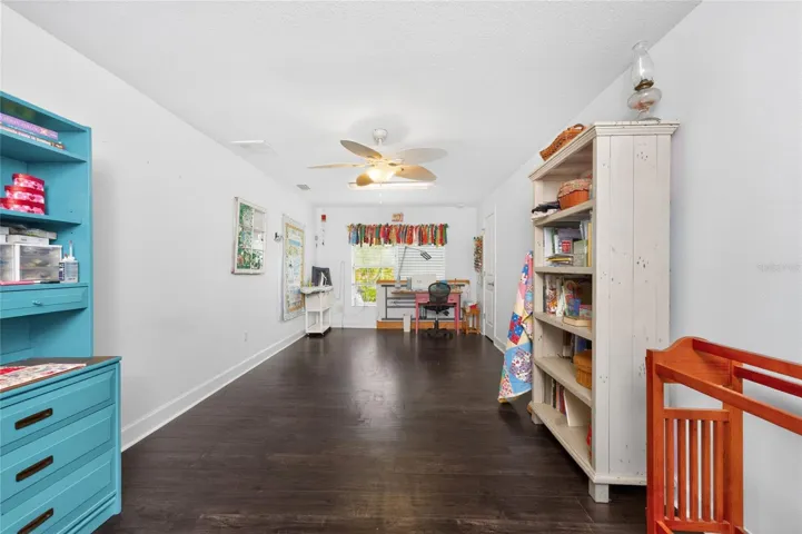 Bedroom 2 features laminate flooring, a ceiling fan and a walk in closet. This was used by the current owner as her craft/sewing room!