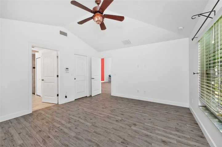 The primary bedroom also has a walk in closet and a vaulted ceiling.