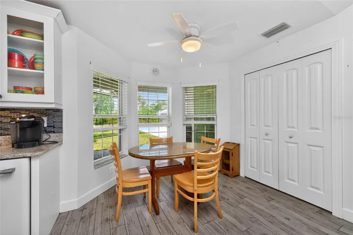 The breakfast nook has a ceiling fan and tiled flooring, plus the closet pantry.