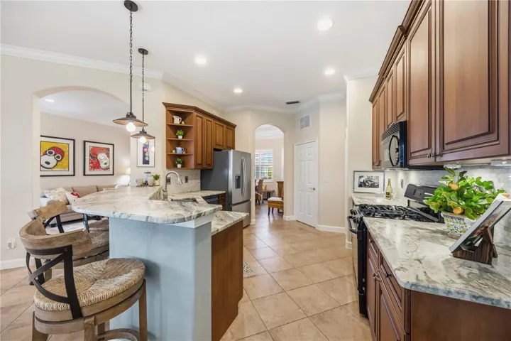 Spacious kitchen with leathered granite countertops with wood cabinets