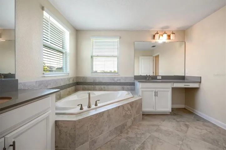 Primary Bathroom w/ dual-sink and plenty of natural lighting and garden tub