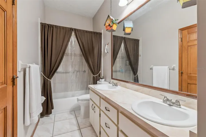 Guest bath: dual vanities, bathtub/shower combo with assistive rail.   Access from hallway and also opens into Bedroom #1.  Can be used as part of a mother- or father-in-law suite.