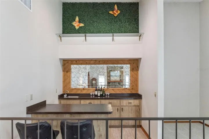 Built-in bar with seating, refrigerator and wet bar
