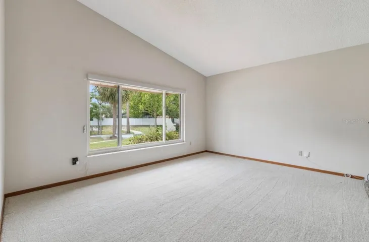 Elevated portion of living room/flex space.  Light and bright with remote-controlled shades.  New carpeting.